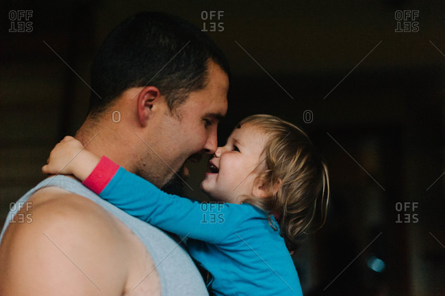 Side view of father cuddles with his daughter