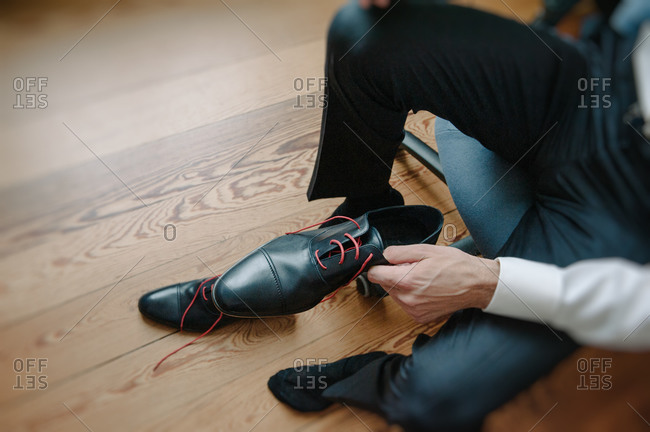 Groom tying his elegant shoes