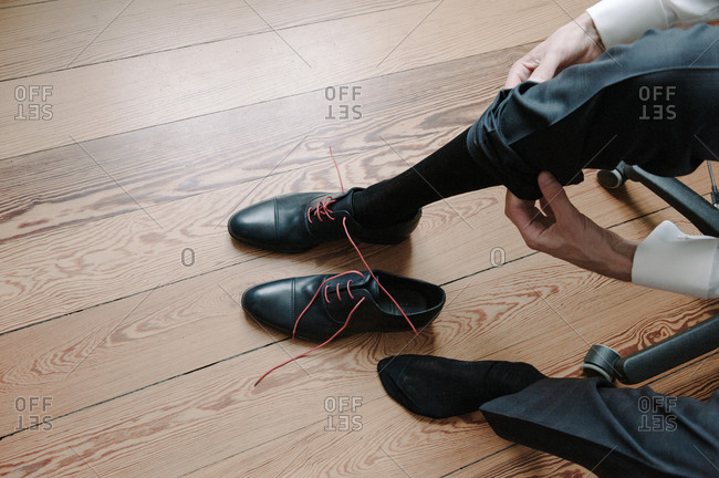Groom tying his elegant shoes