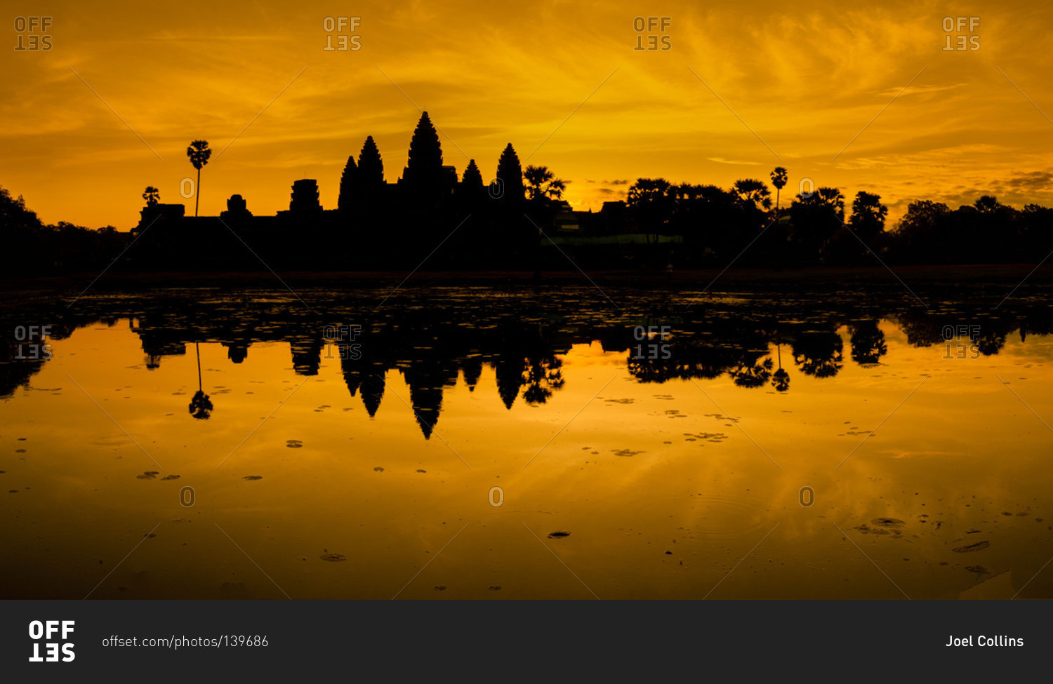The temples of Angkor Wat silhouetted against a dramatic orange sunrise, Cambodia