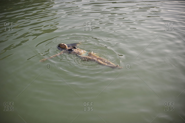 Woman floating in lake - Offset