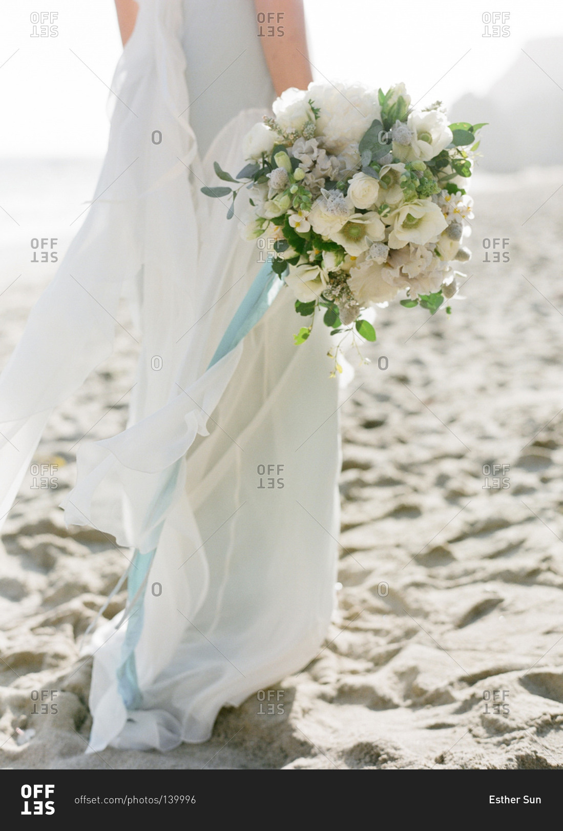 Close up of bride holding a flower bouquet on the beach