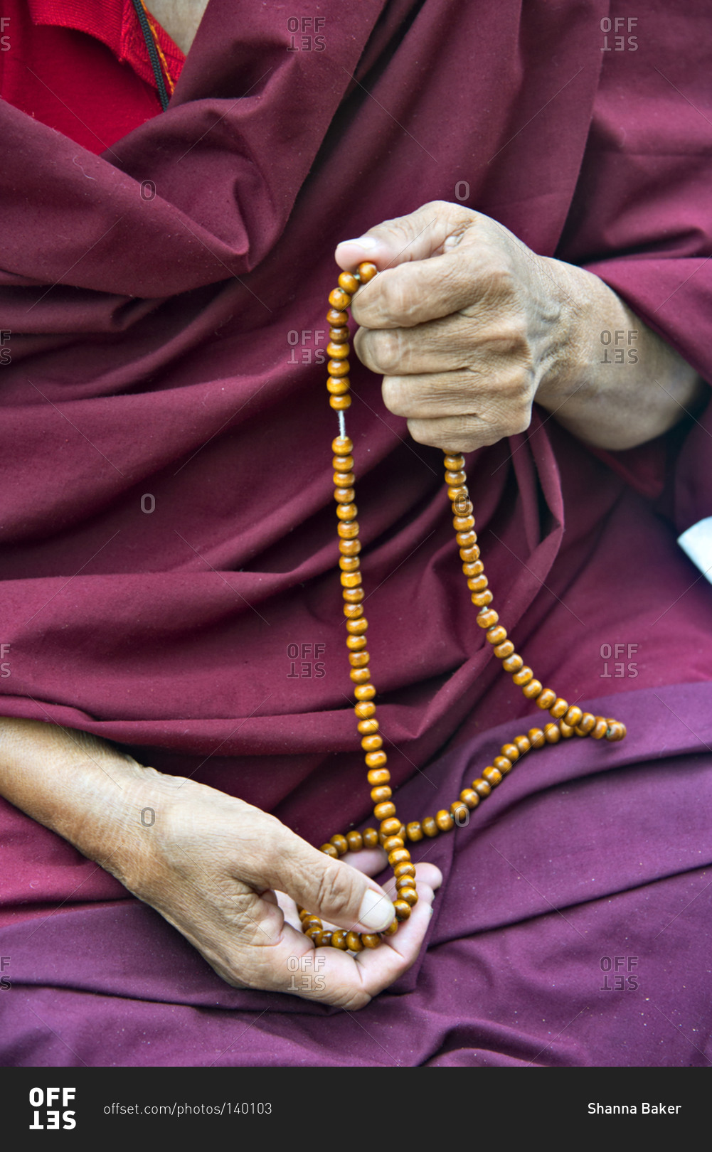 Detail of Buddhist monk holding prayer beads at the Mahabodhi Temple Complex in Bodh Gaya, India