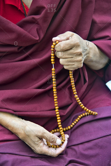 Detail of Buddhist monk holding prayer beads at the Mahabodhi Temple ...