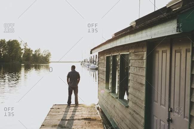 A man standing on the edge of a dock looking out over the ocean