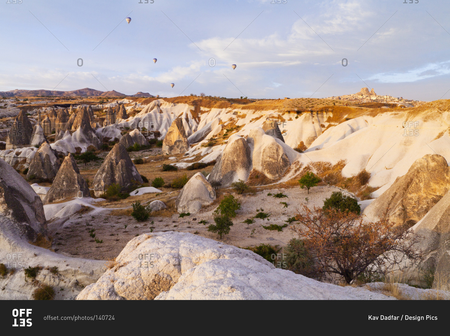 Hot air balloons over a landscape of rugged rock formations and cliffs, Goreme, Cappadocia, Turkey