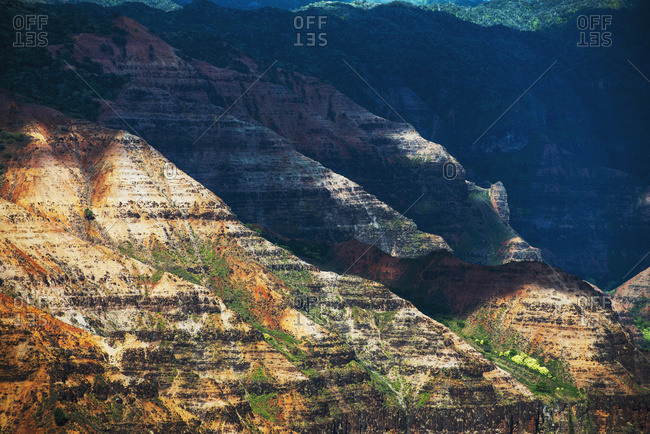Sunlight brightens the slopes of the canyons in Waimea Canyon State Park, Kauai, Hawaii,