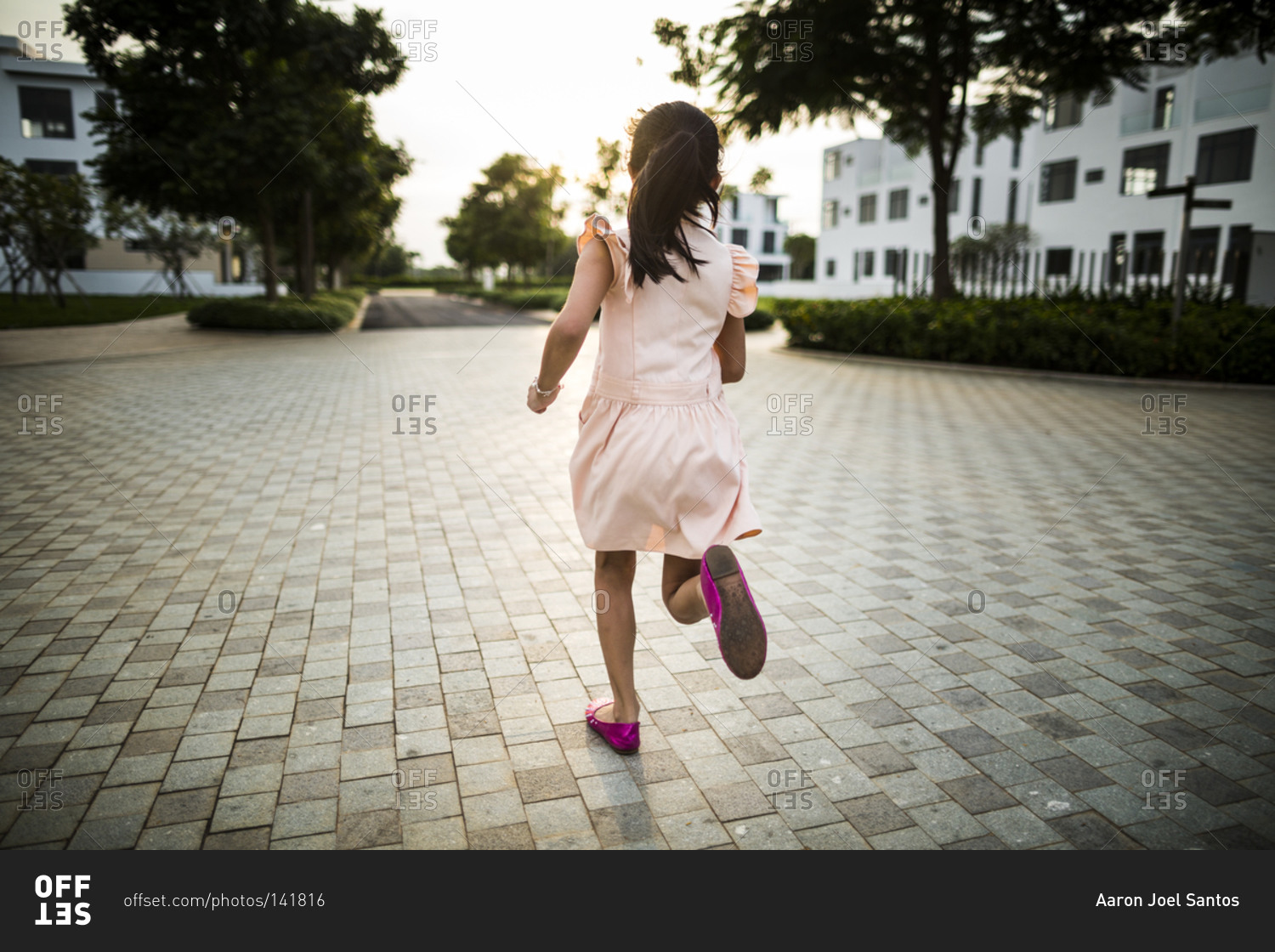 Young Vietnamese girl runs through a private drive as the sunsets in a suburban housing complex in Ho Chi Minh City, Vietnam