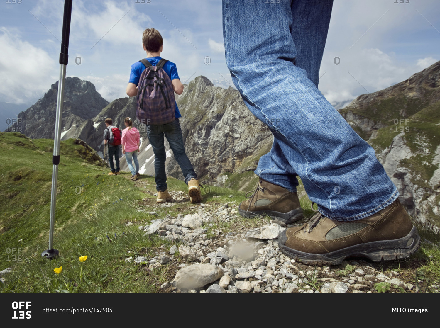 Father teenage kids hiking in mountains Alps