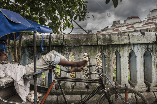 India - July 31, 2014: Cycle rickshaw driver takes a rest
