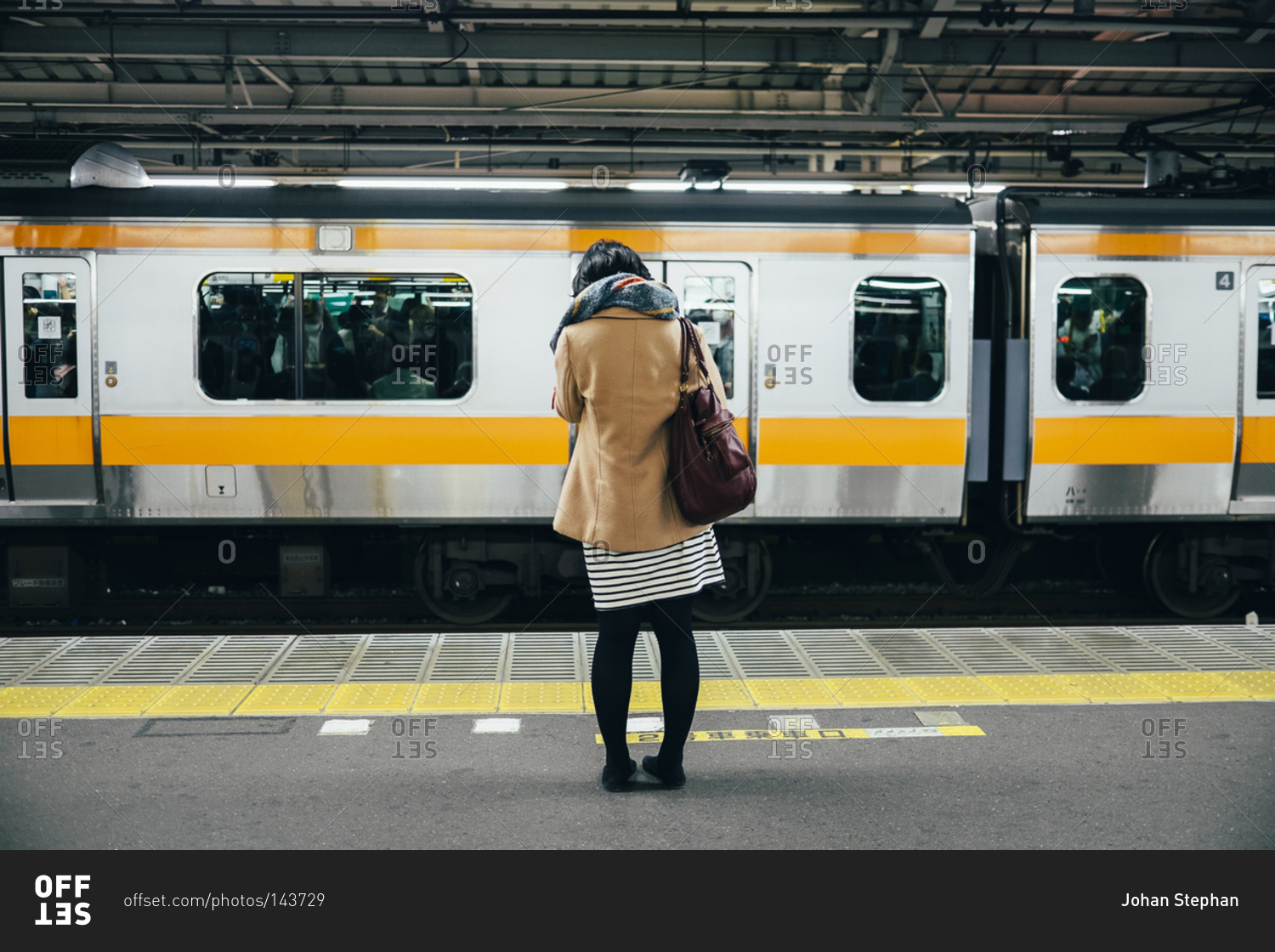 A woman waits for a subway train