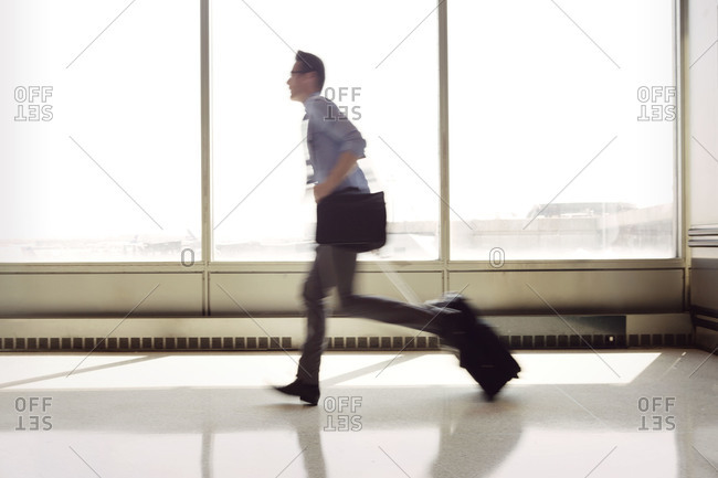 Man running down airport terminal