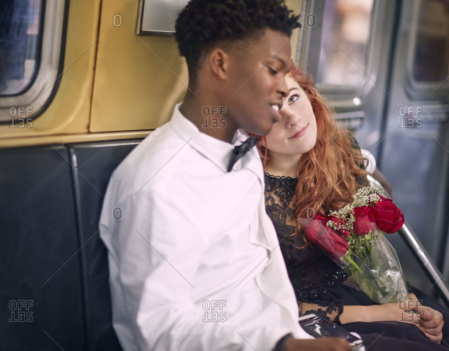Couple cuddling on subway train