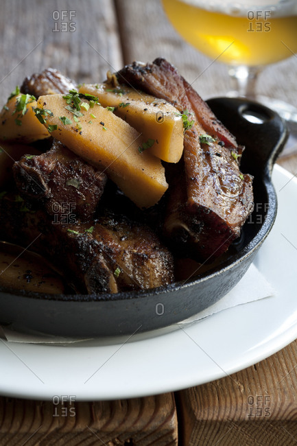 A rib dinner is served on an iron pan