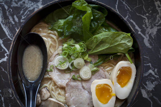 An egg and pork belly float in a bowl of ramen soup