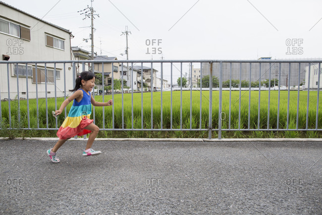 A young girl running along a footpath
