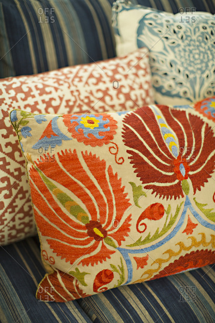 Three different embroidered cushion on a couch