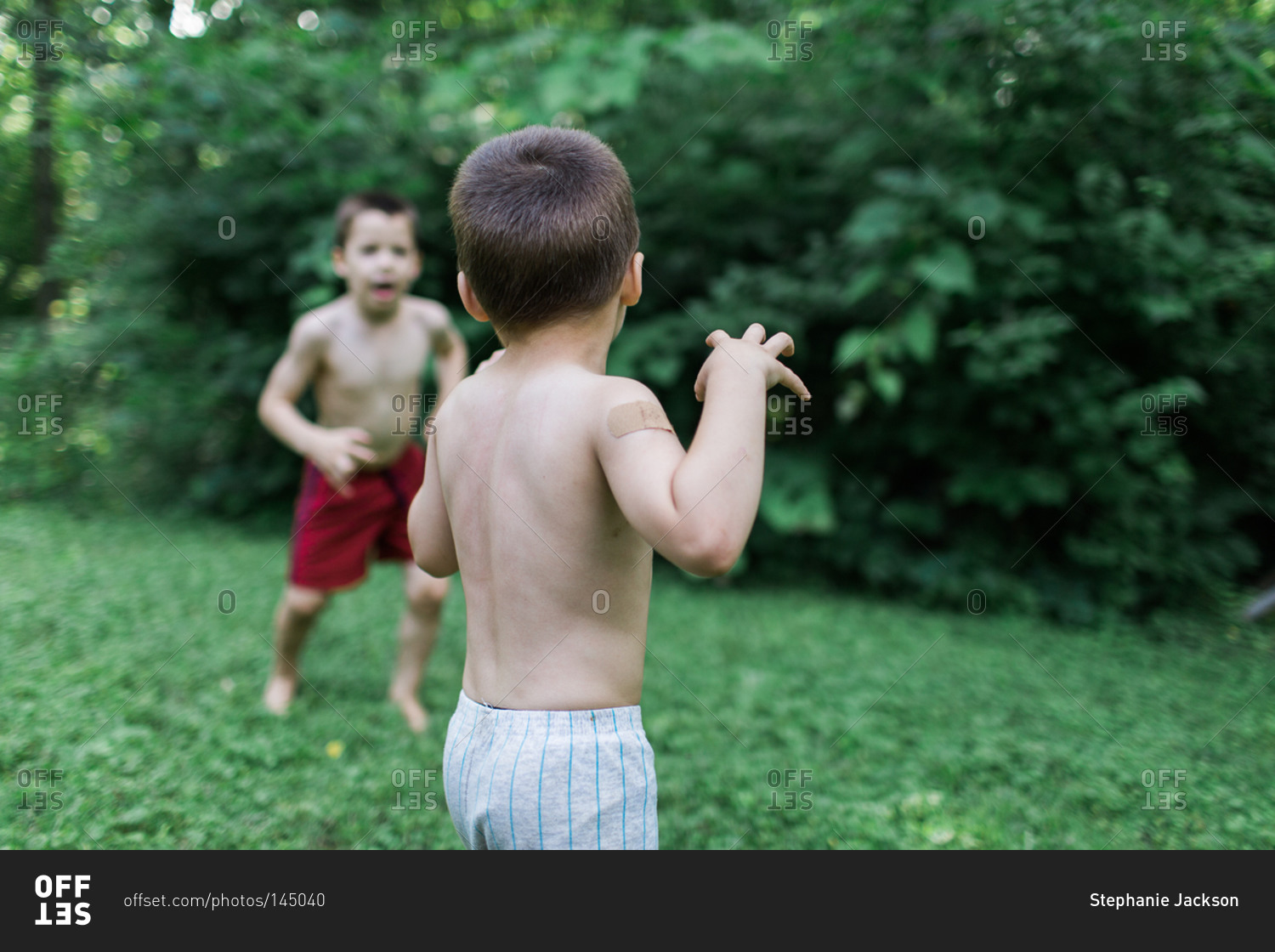 Brothers playing in the garden stock photo - OFFSET