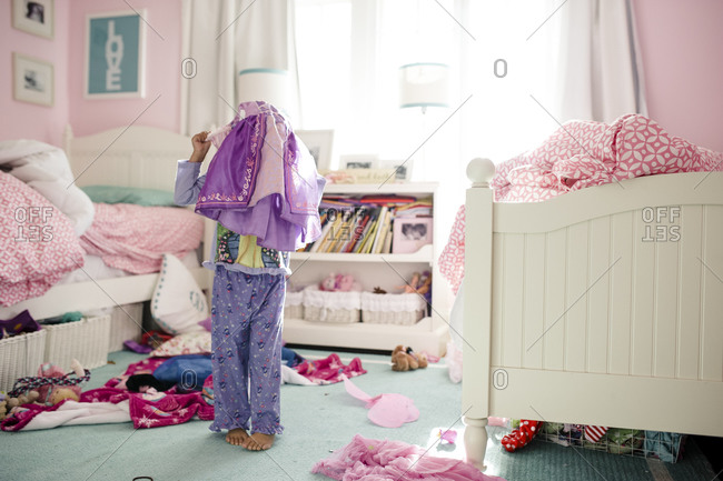 Little girl putting princess costume over pajamas stock photo - OFFSET