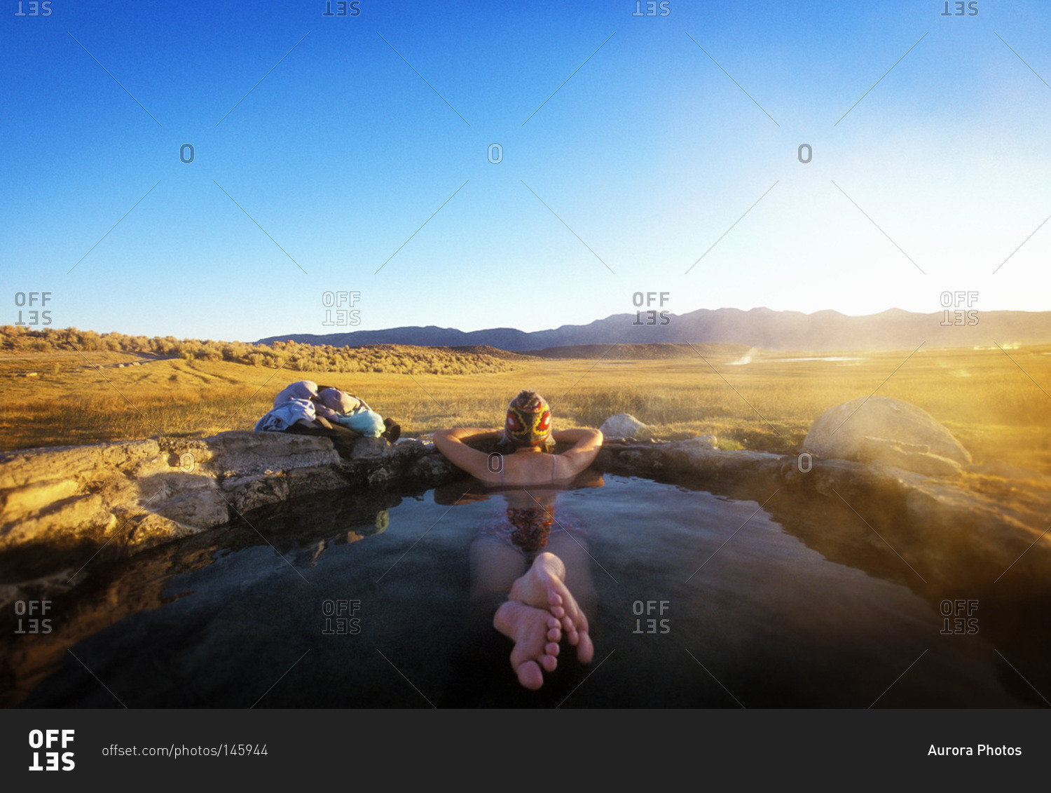 Woman resting in hot spring watching the landscape, Eastern Sierra region, USA