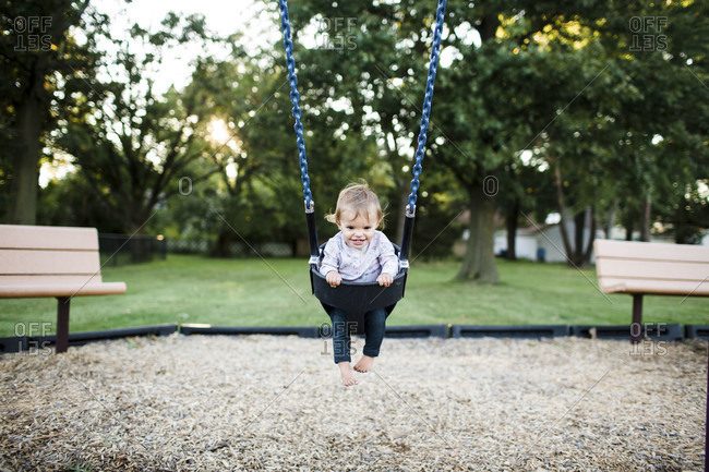 A Baby Swings In A Park Stock Photo Offset