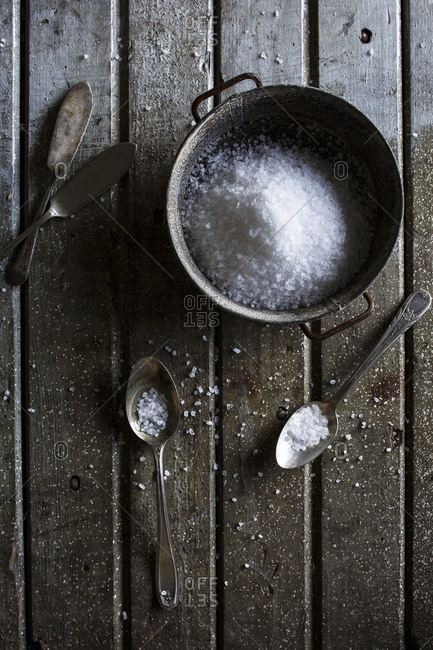 Coarse salt in a bowl with spoons and knives
