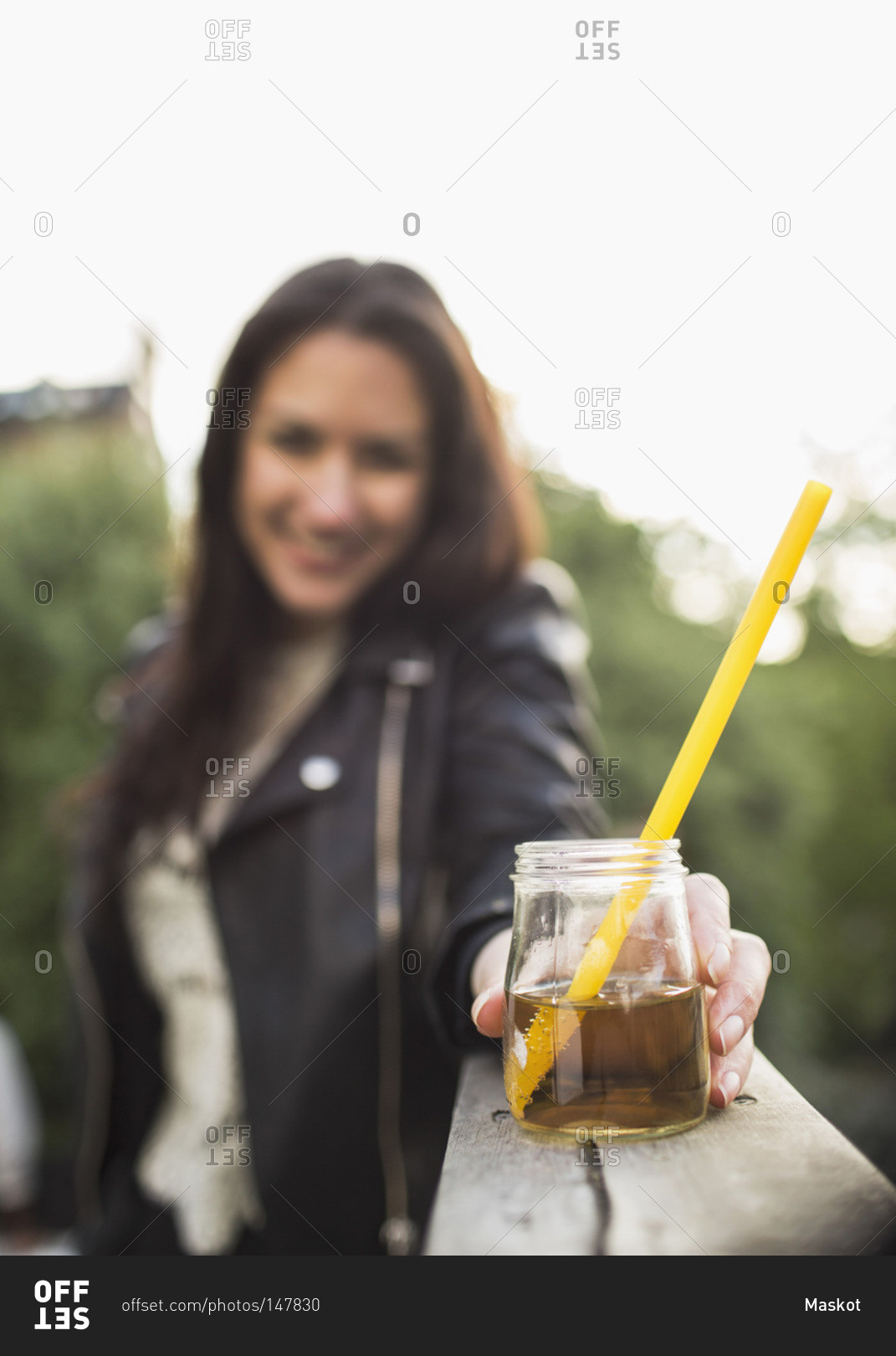 Woman holding elderflower drink on roof garden