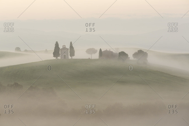 Chapel in morning mist in Tuscany