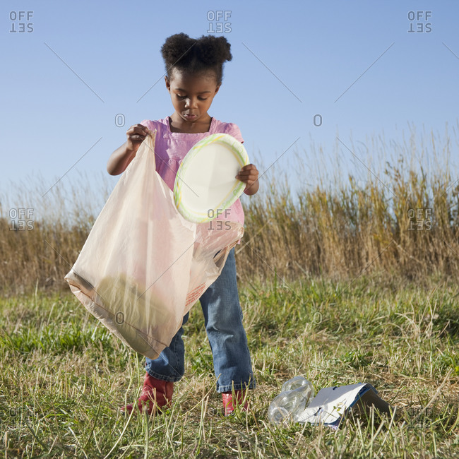 Young girl picking up litter