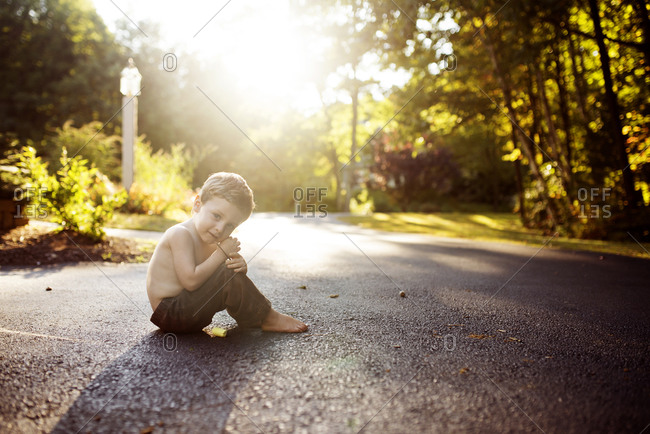 Shirtless boy in driveway