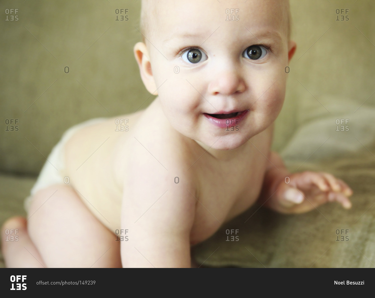 A baby in a diaper on a couch stock photo OFFSET