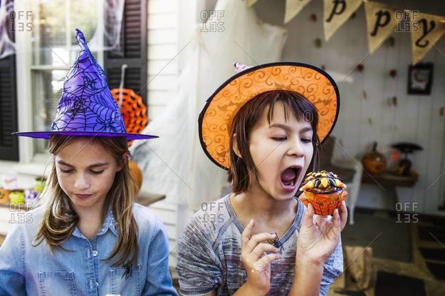 Young girls eating Halloween cupcakes