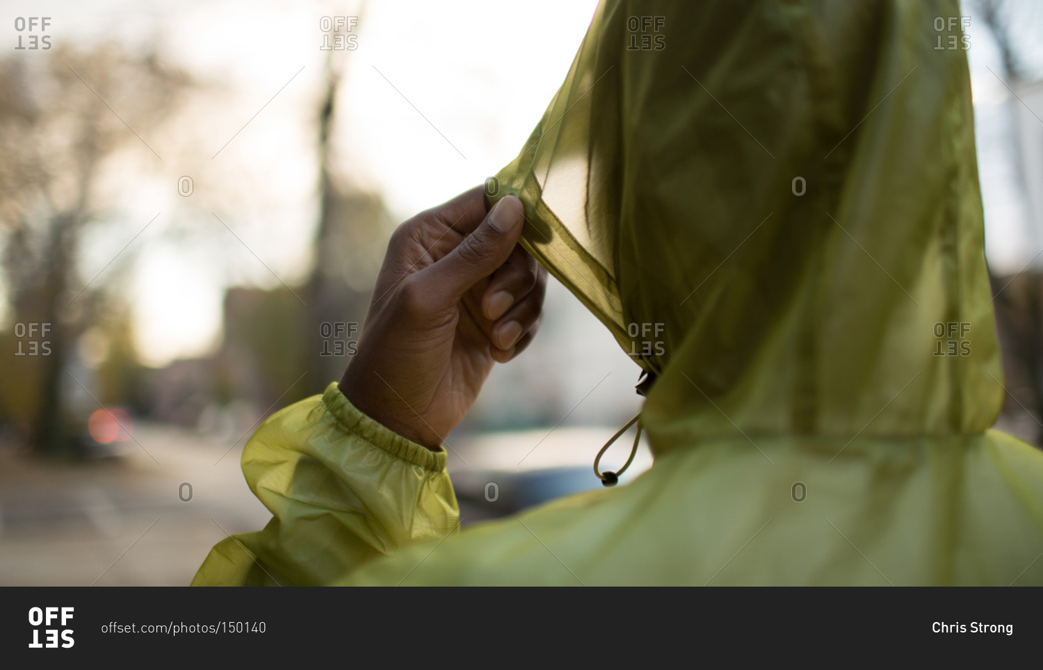 Man pulling up rain coat hood
