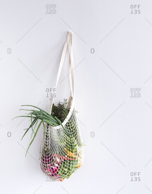 Fresh vegetables in a bag hanging on a wall