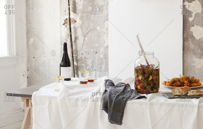 Tomato pickles served with bread and wine on a dinner table