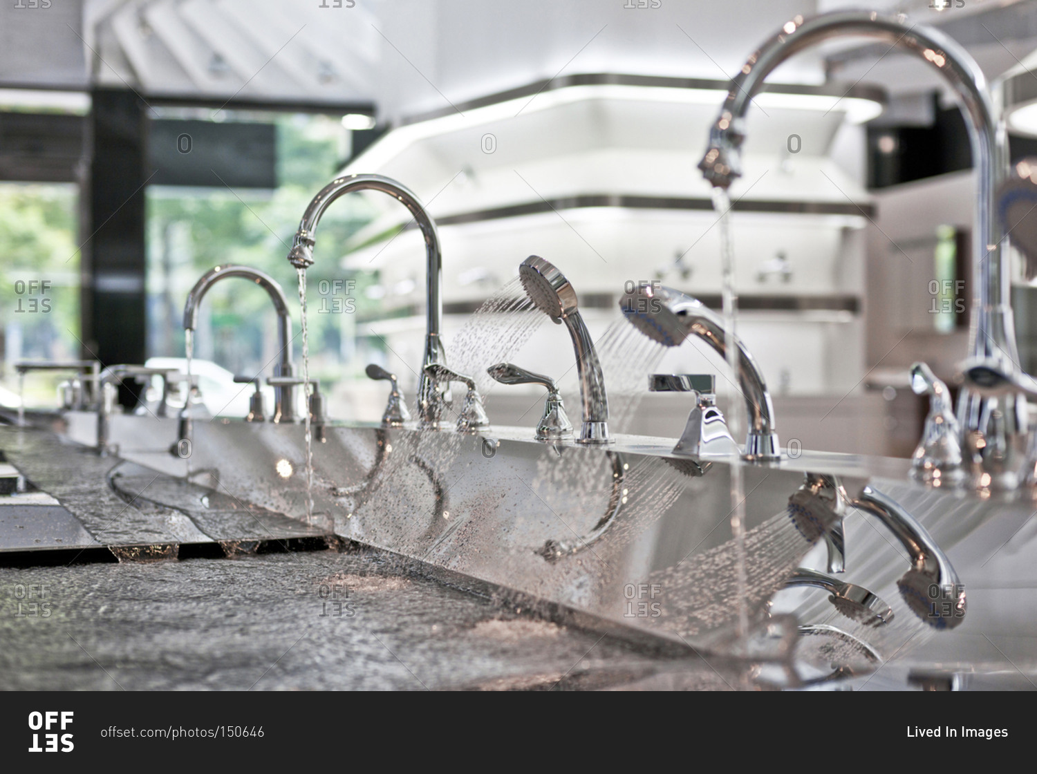 Faucets with running water on in kitchen and bath showroom