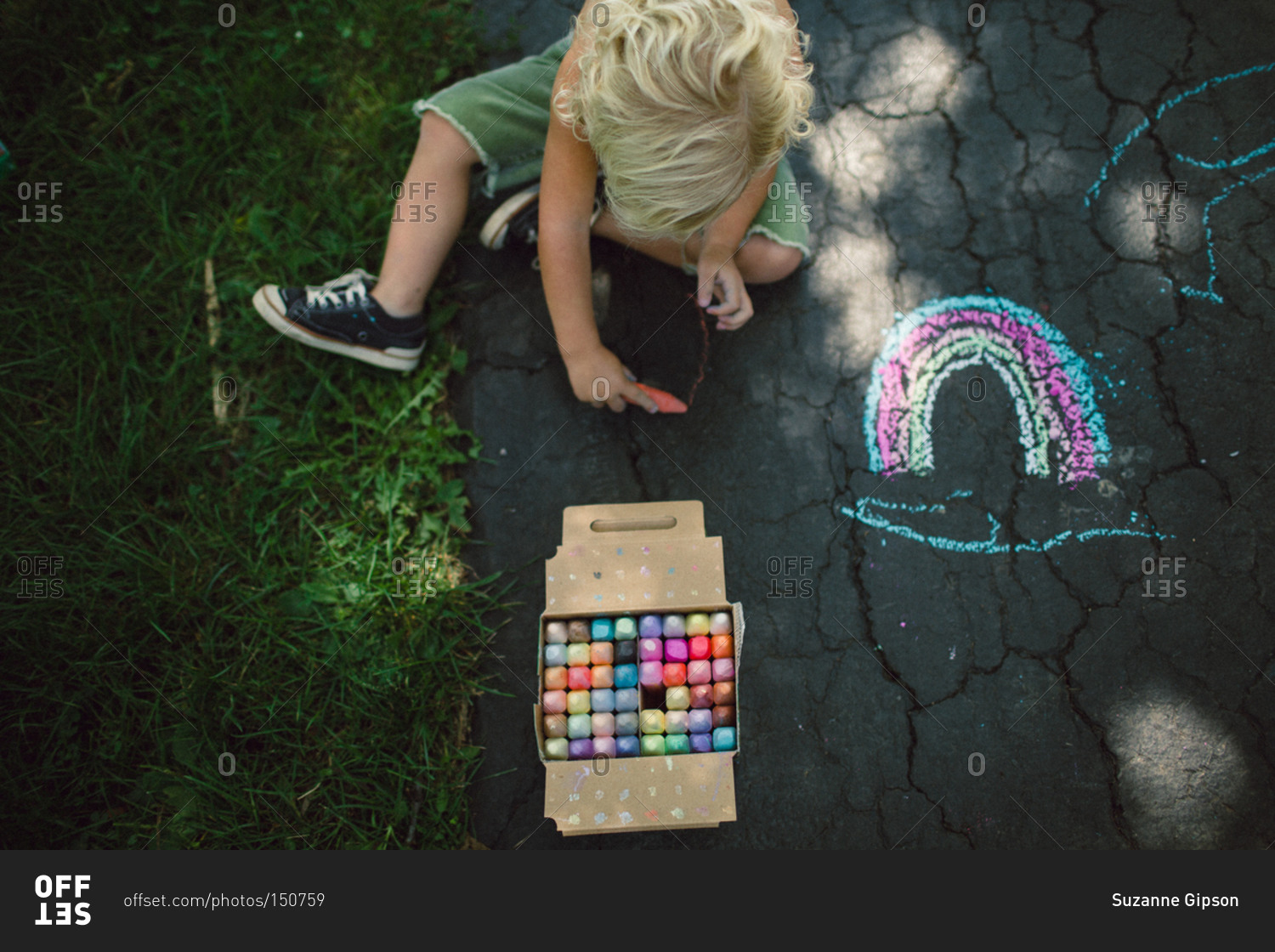 Boy drawing a rainbow in chalk