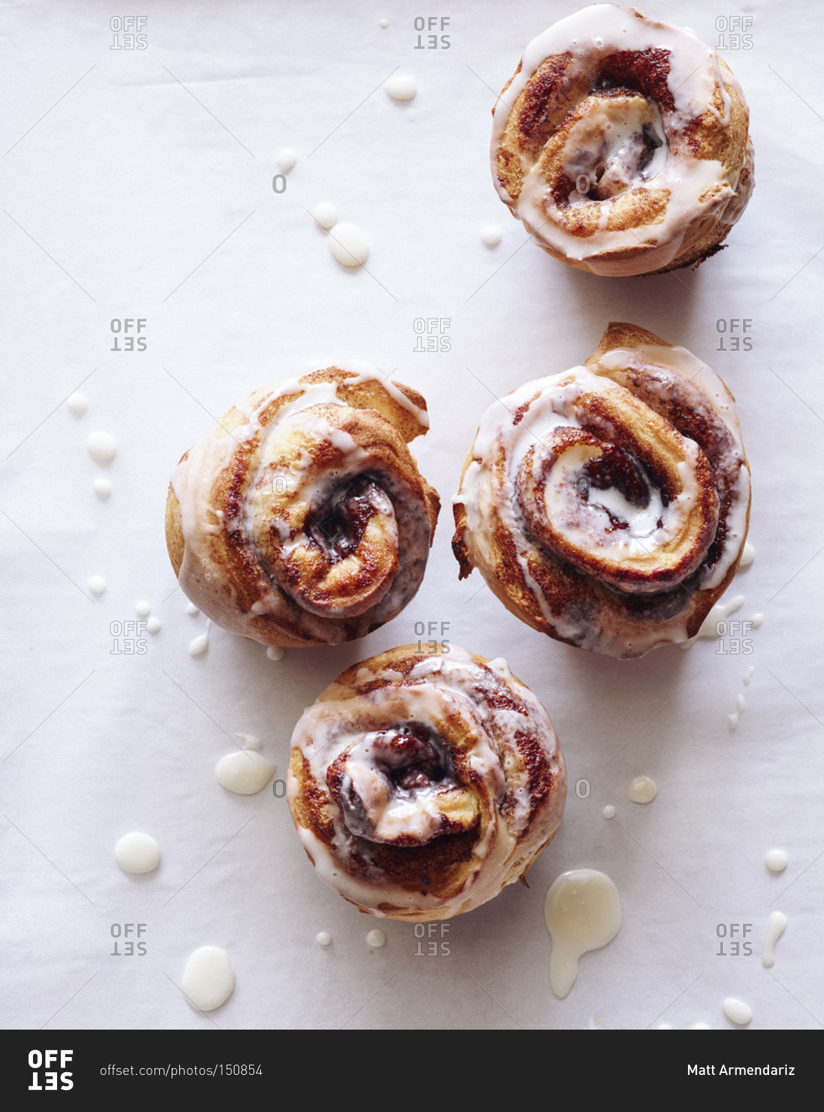 Four cinnamon rolls on white background from above