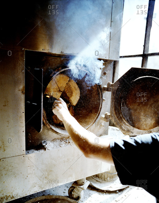 Person lighting the wood for the smoker