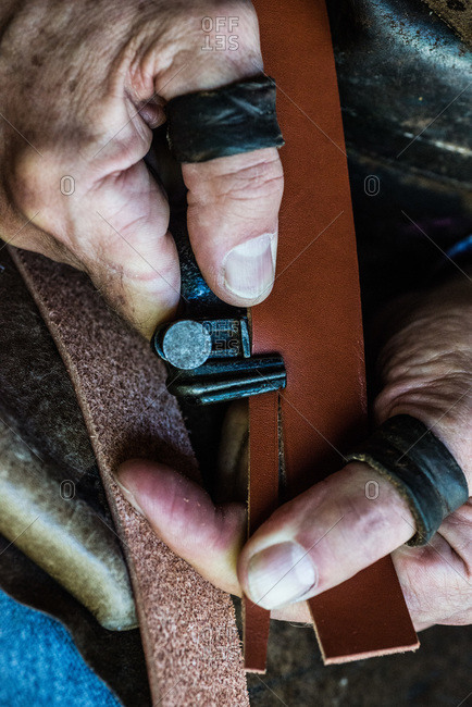 Artisan cutting a piece of leather