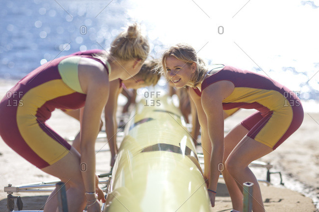 Female rowers lifting up boat