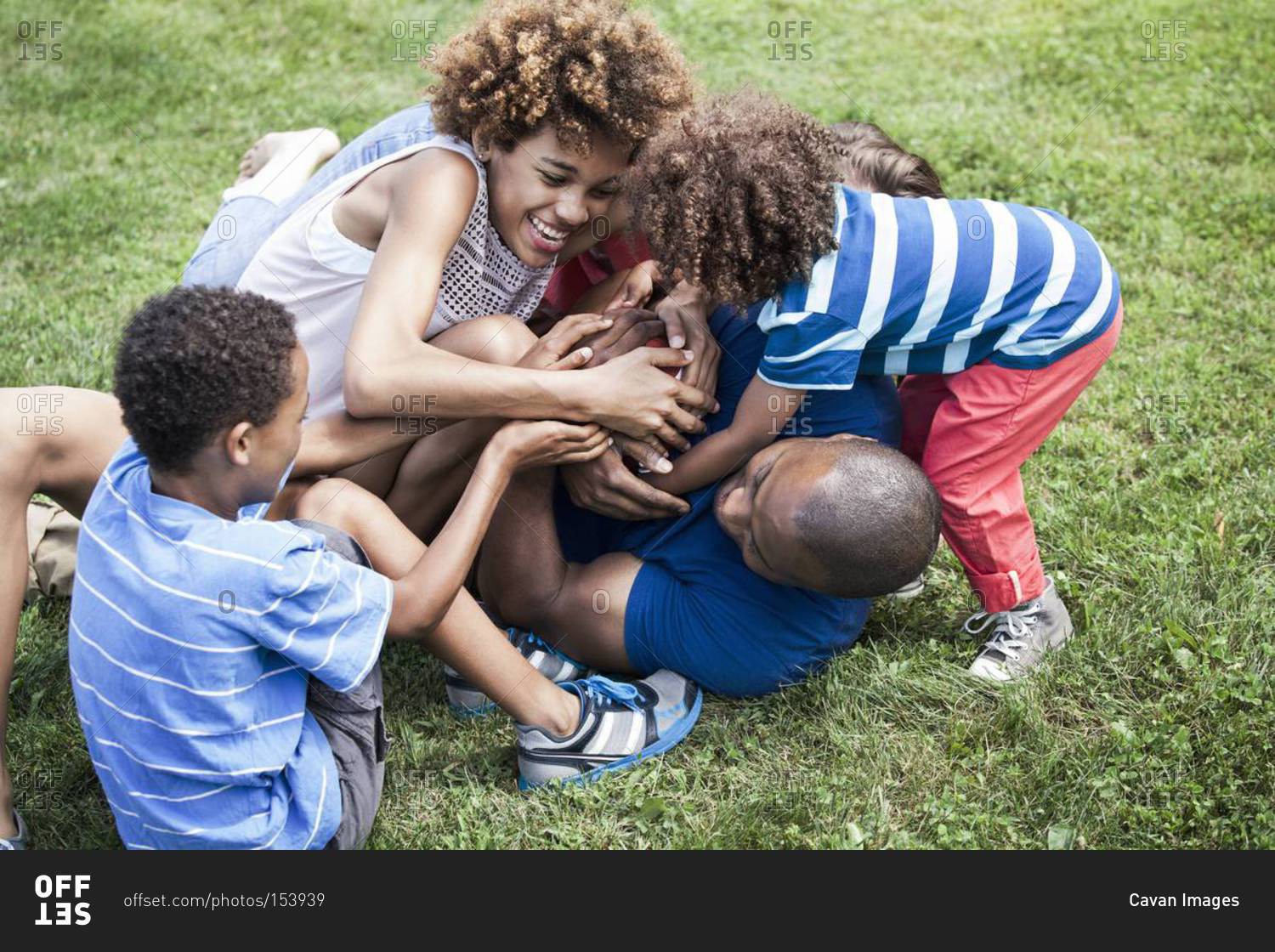 Happy family wrestling in the grass