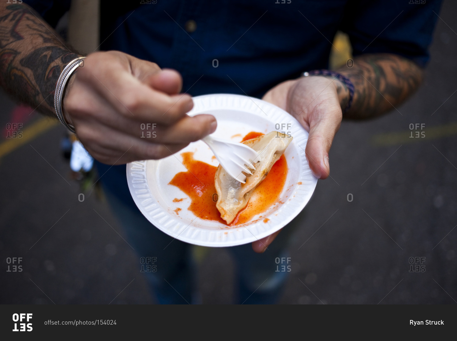 Man eating street food on plastic plate