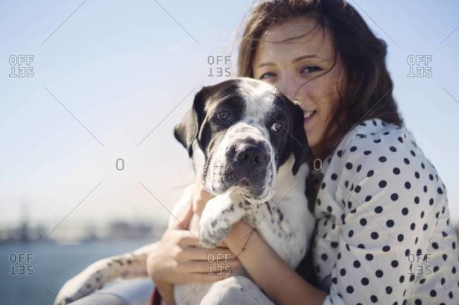 Young woman cuddling her dog