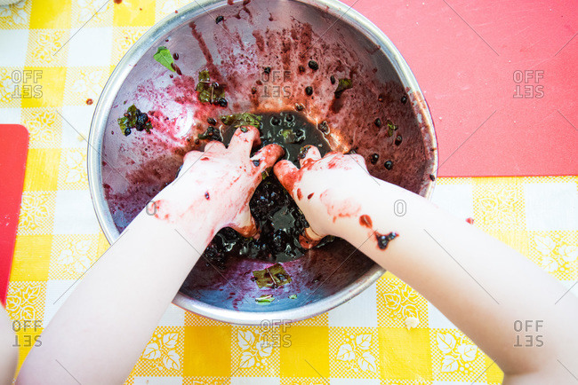 Child making a blackberry dessert