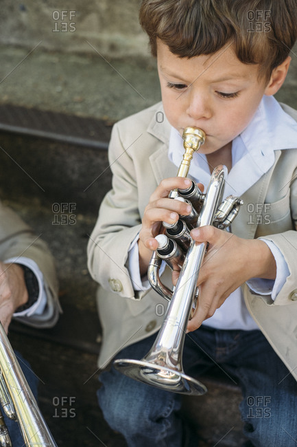 Boy on steps playing trumpet