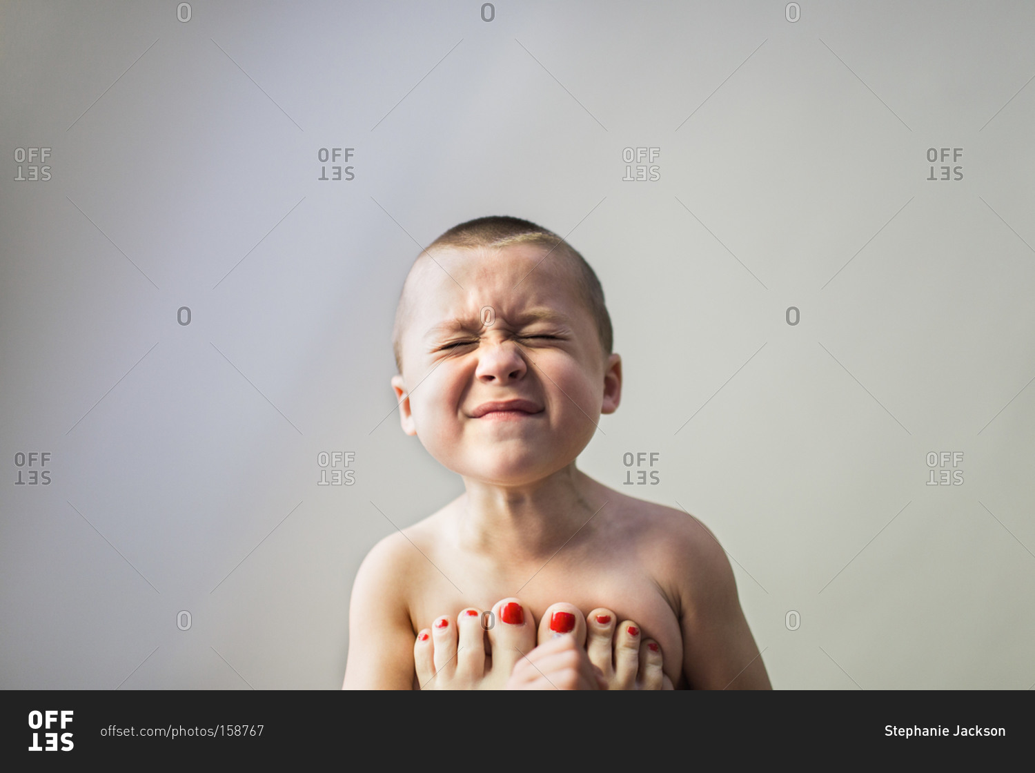 Woman pressing a young boy's chest with her feet stock photo OFFSET