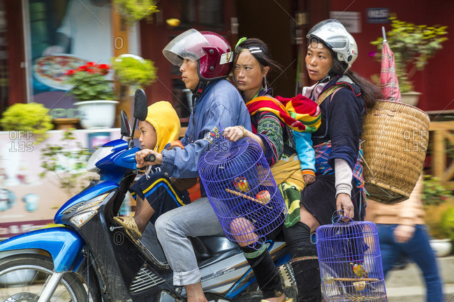 Sapa, Vietnam - April 8, 2014: Black Hmong tribes carrying bird cages on a scooter