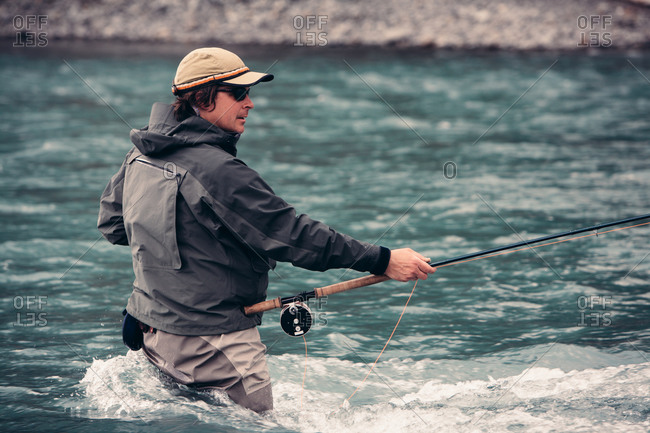 Fly-fisherman standing in river, casting line, Hoh River, Olympic NP, WA, USA