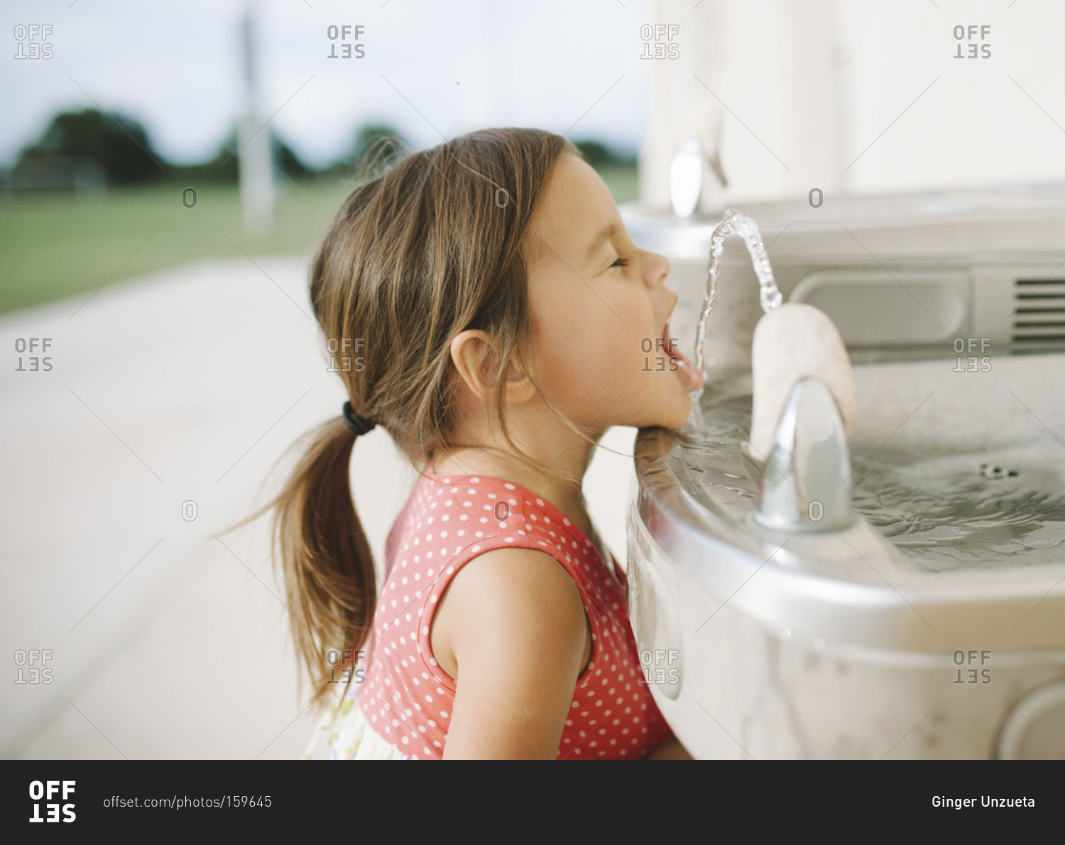 Portrait of a young girl at a drinking fountain